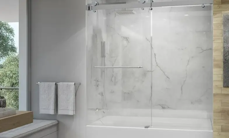 Bathtub sliding shower door with frameless glass panels and a sleek design in a modern bathroom with marble walls.