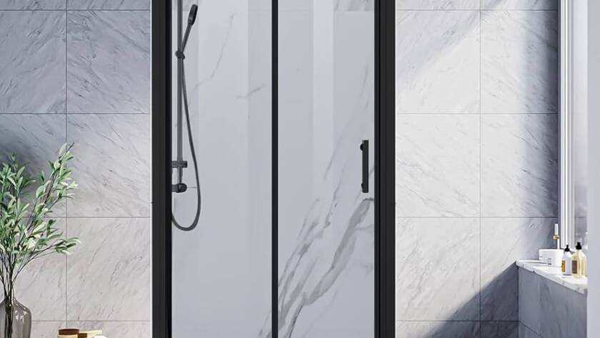 Bi-fold shower door with a matte black frame, clear glass panels, and marble tile in a modern bathroom.