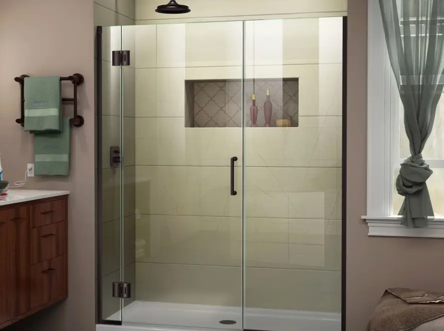 Hinged shower door with clear glass panels and matte black hardware in a modern bathroom with beige walls and a tiled shower.