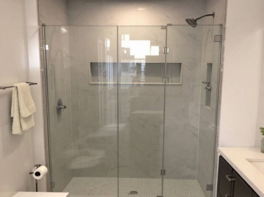 Professional installation of modern, contemporary bi-fold shower doors by Glass Shower Doors Installation in Boston.