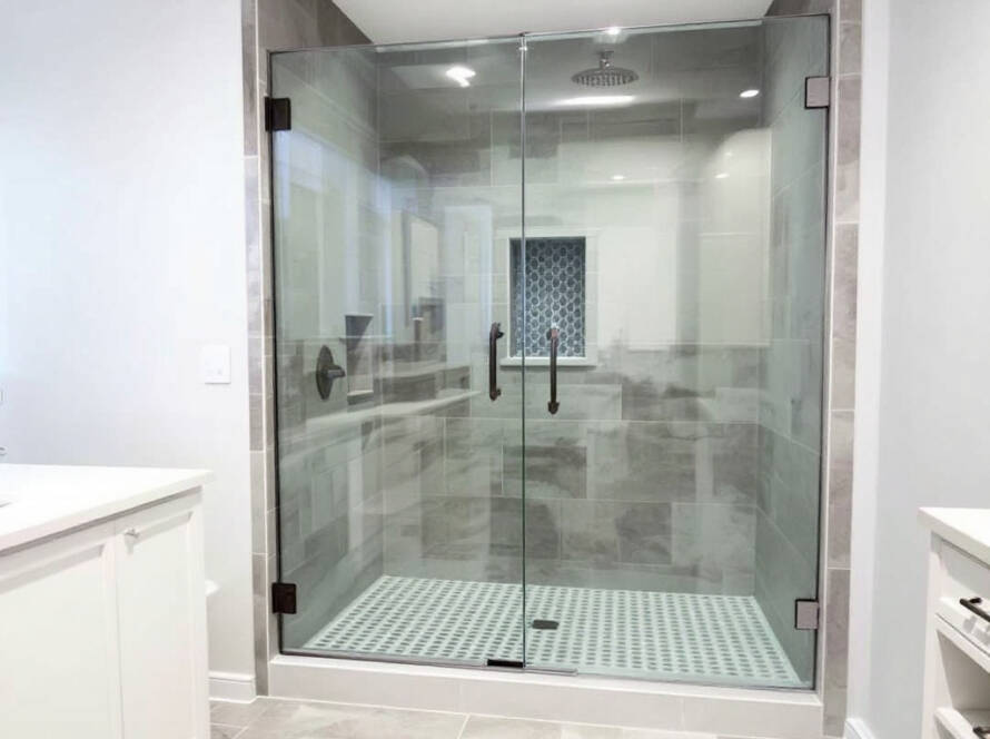 Professional working on a modern designed shower door installation in Sudbury, MA.