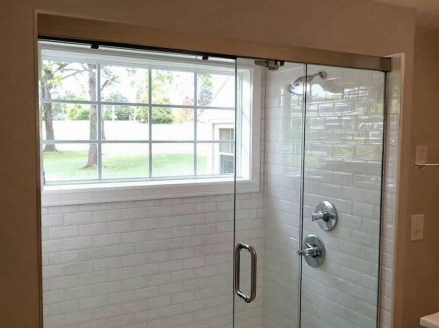 Expert tradesmen demonstrating contemporary sliding shower door installation near Wakefield, MA.